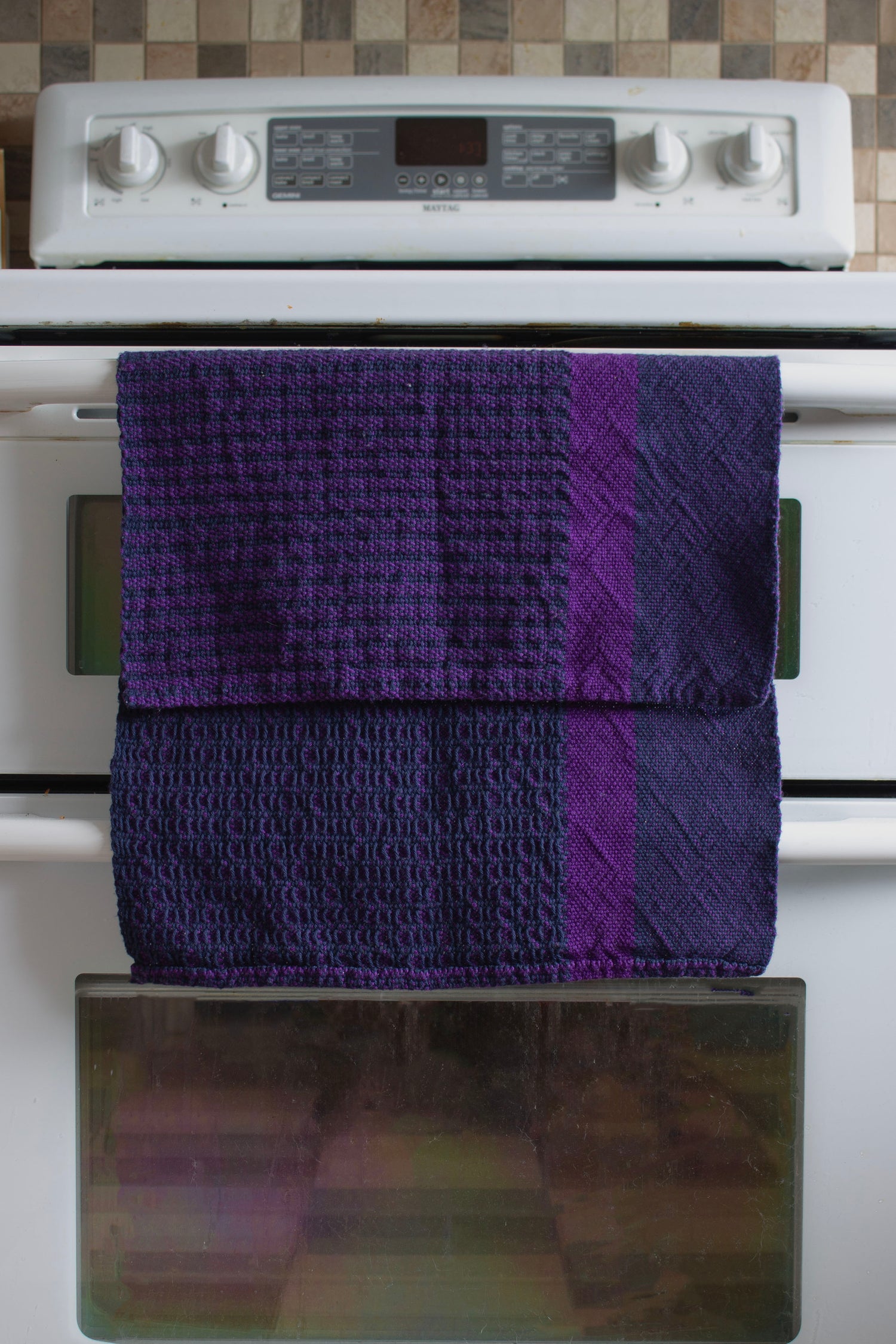 Cotton dish towel, navy blue window weave, purple, handmade, natural fibres, locally sourced yarn, washer and dryer safe, absorbent, soft, lightweight, hemstitched, hemmed, hand sewn hem, woven in Canada